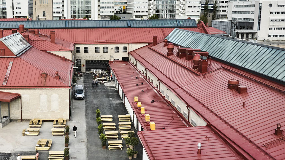 Ovanifrånperspektiv på byggnader i ett industriområde med röda plåttak, foto
