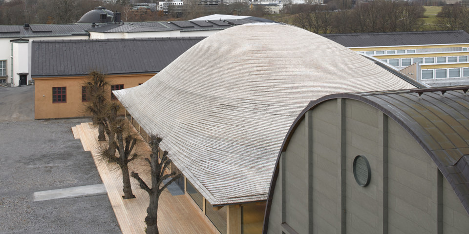 Modern träbyggnad med ett böljande tak, foto.